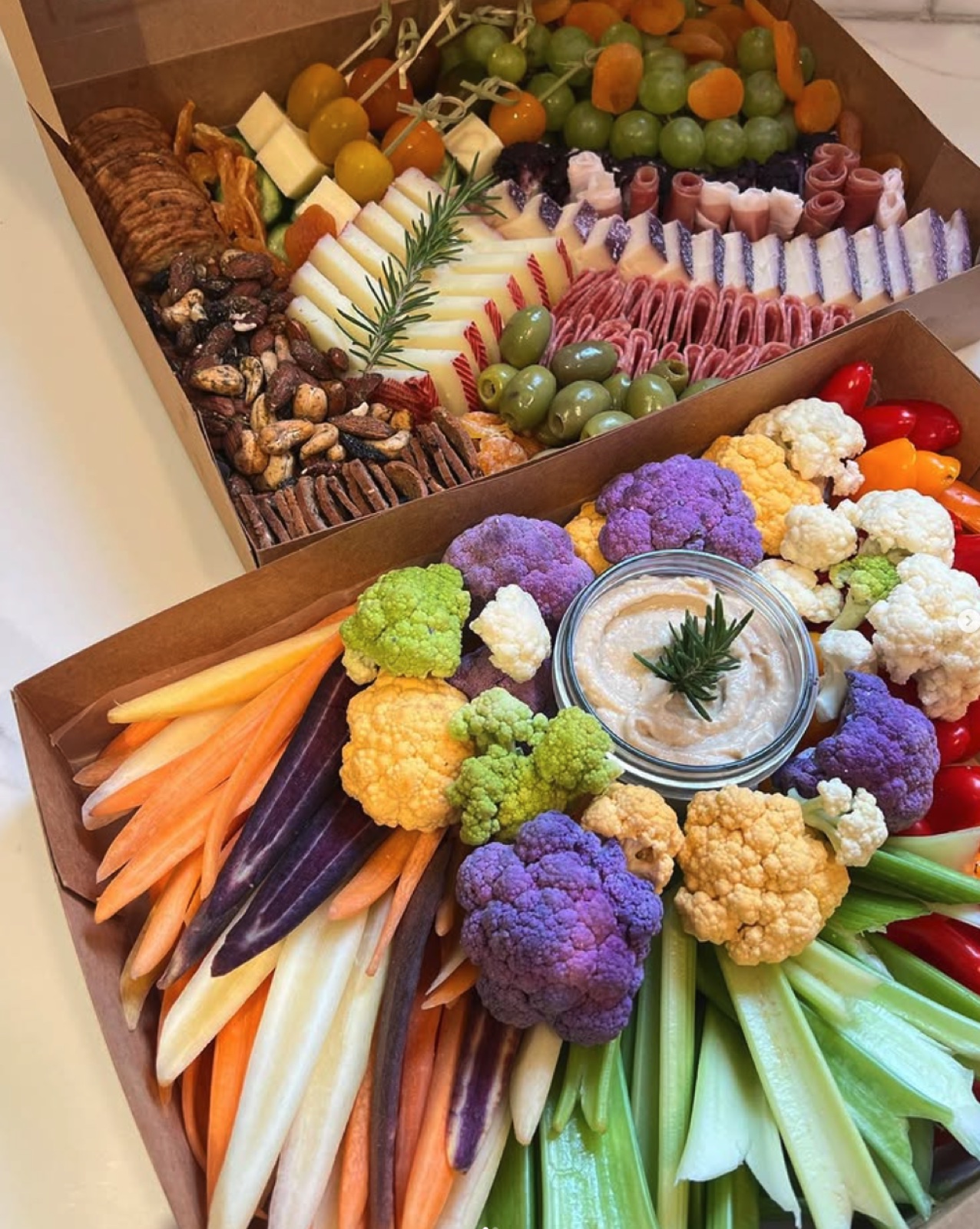 Charcuterie box beside rainbow crudité box