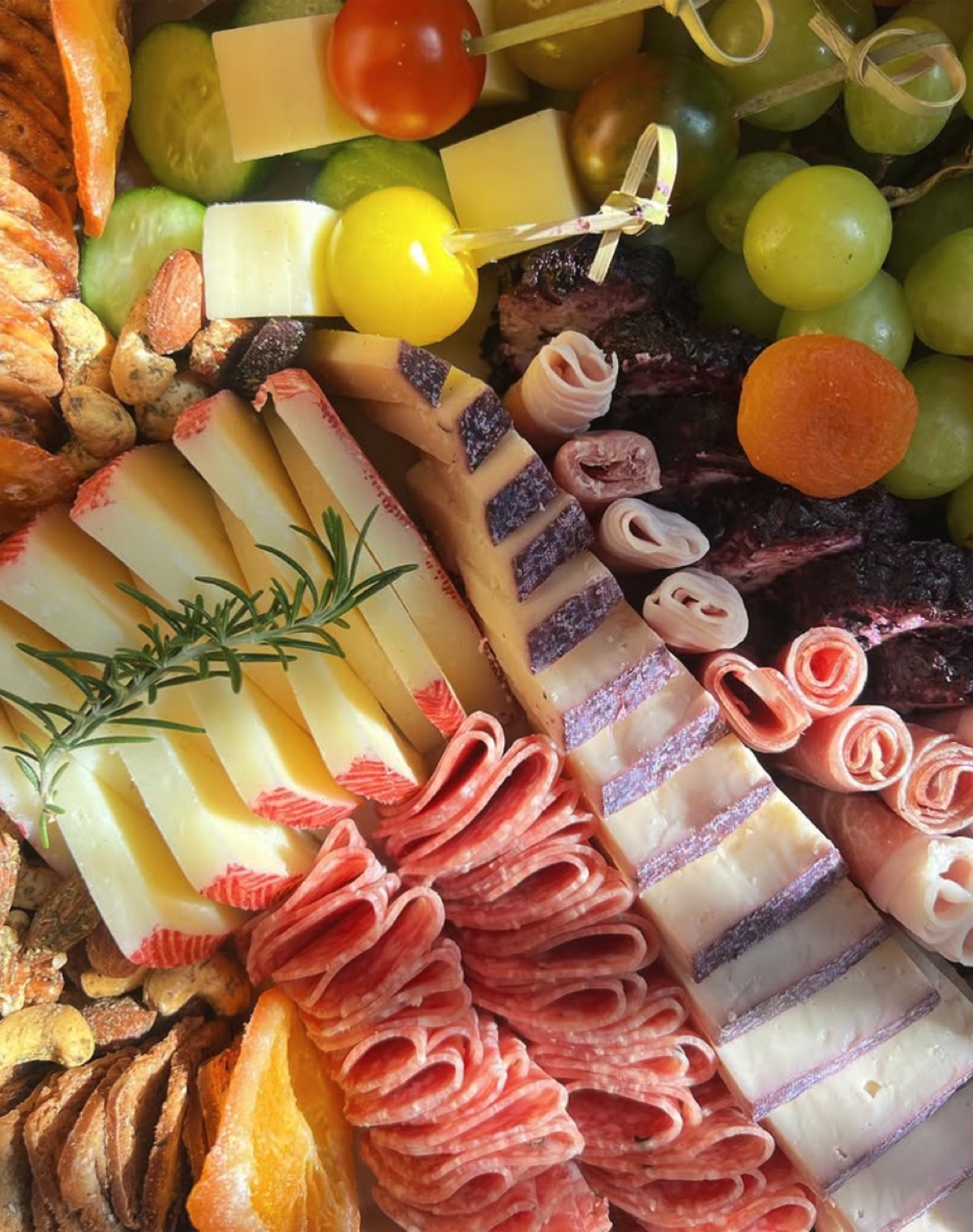 Close-up of marbled cheese, salami coils, dried orange