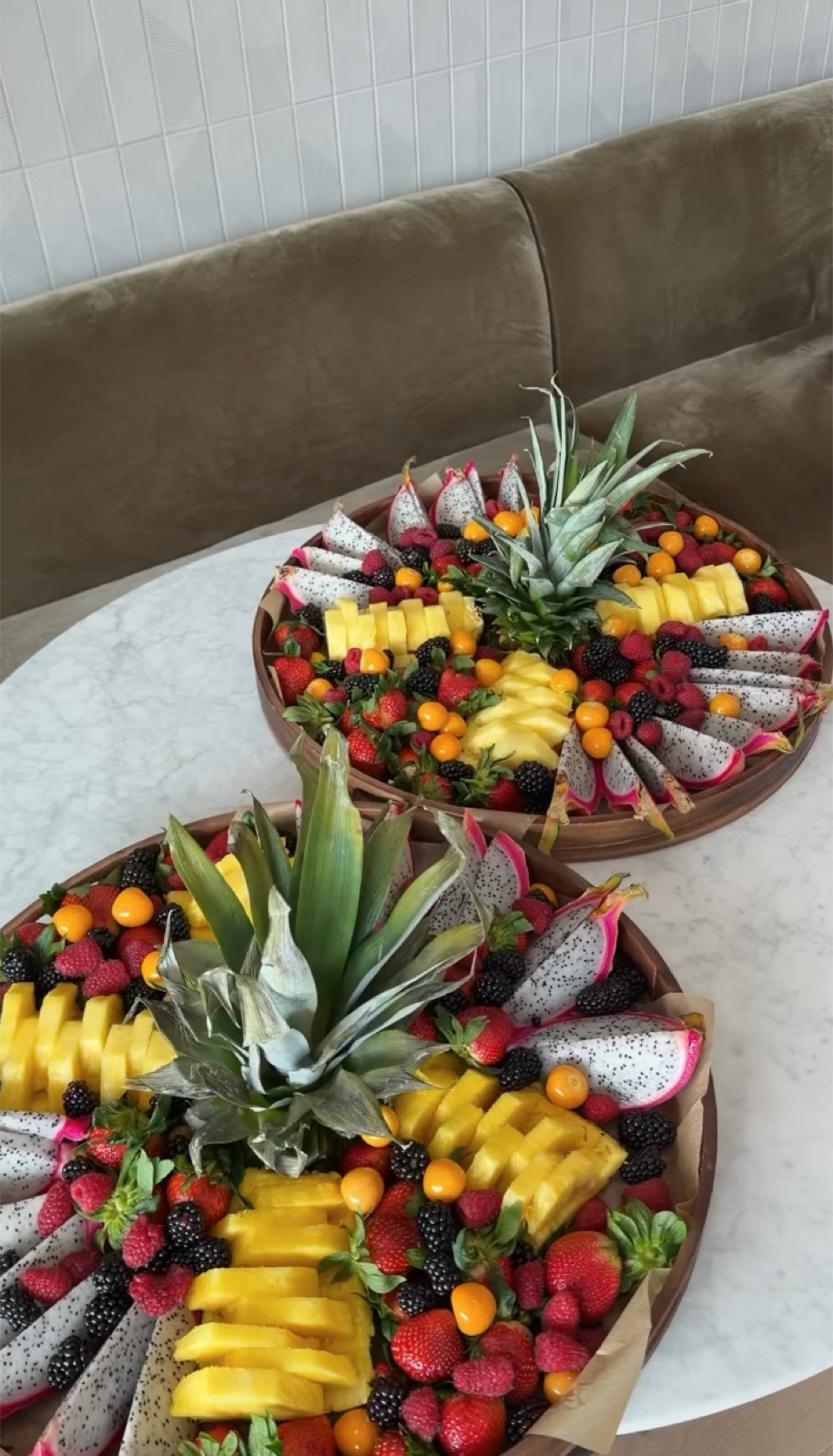 Round wooden platters piled with fresh fruit